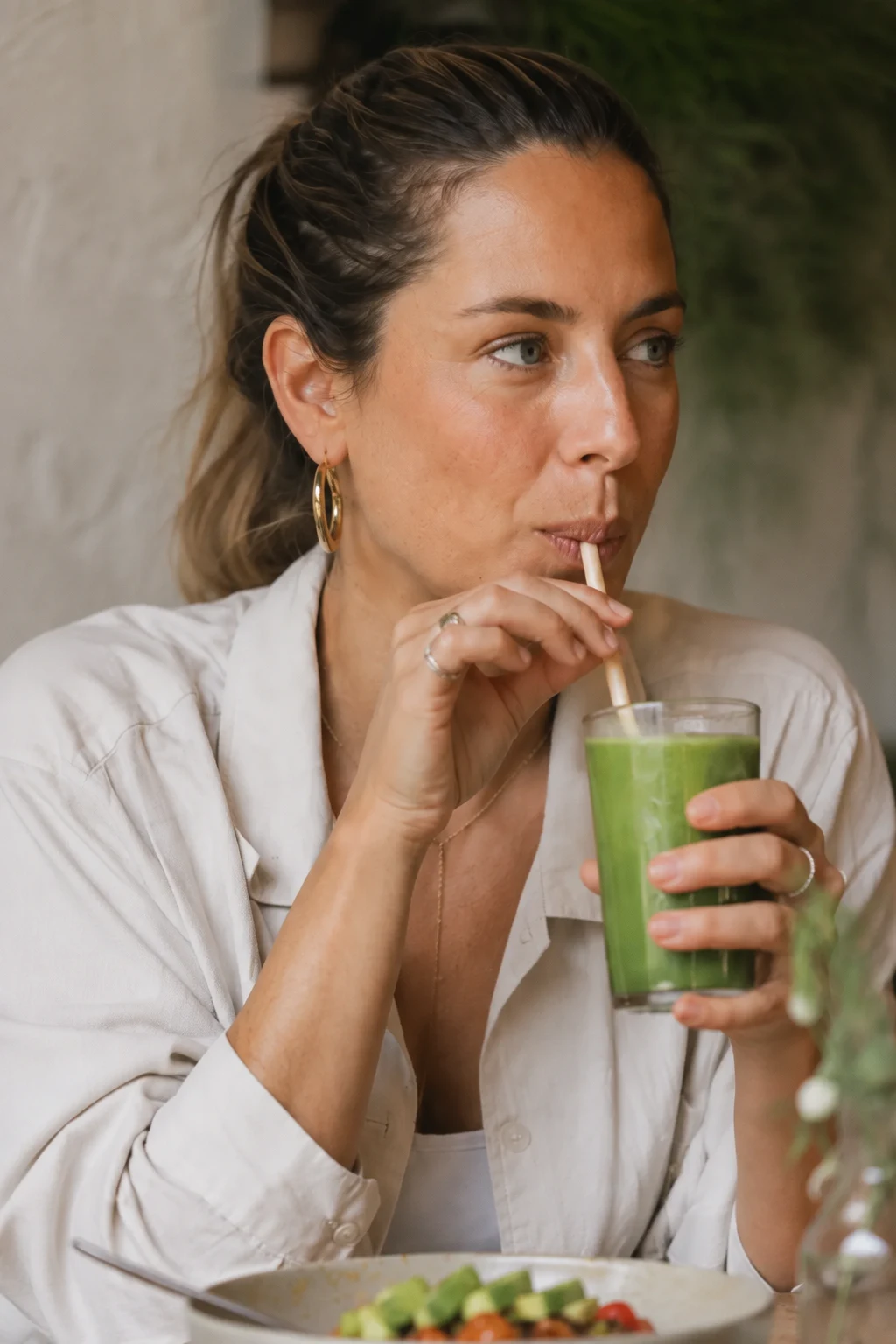 A woman enjoying a fresh green drink in a warm neighbourhood café